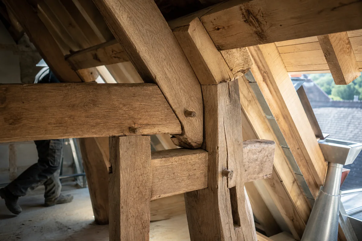 Charpente traditionnelle en chêne avec assemblages tenon et mortaise dans des combles